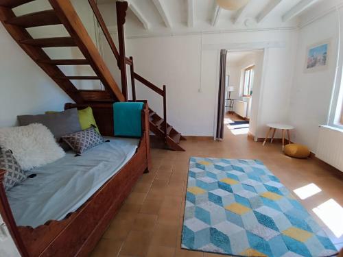 a living room with a bed and a staircase at Gites de la Bénardière in Vallières-les-Grandes