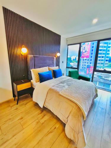 a bedroom with a large bed and a large window at Republica del Salvador Coliving Ecuador XOE in Quito