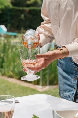 une personne tenant un verre de vin sur une table dans l'établissement Room in Guest room - Guest room in an exceptional villa, au Pradet