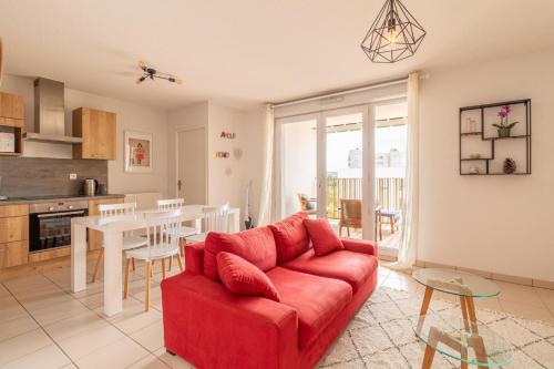 un salon avec un canapé rouge et une table dans l'établissement Nice T2 with a large furnished balcony in Toulouse, à Toulouse