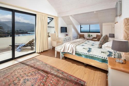 a bedroom with a bed and a large window at Hermanus Luxury Penthouse in Hermanus