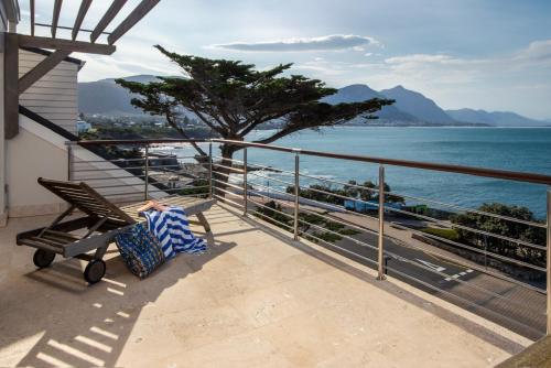 a bench sitting on a balcony looking at the ocean at Hermanus Luxury Penthouse in Hermanus
