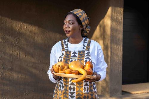 a young girl holding a plate of fruit and vegetables at Nambiti Hills in Nambiti Private Game Reserve