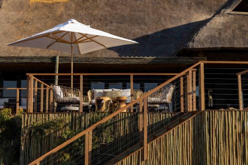 a patio with an umbrella and a table and chairs at Nambiti Hills in Nambiti Private Game Reserve