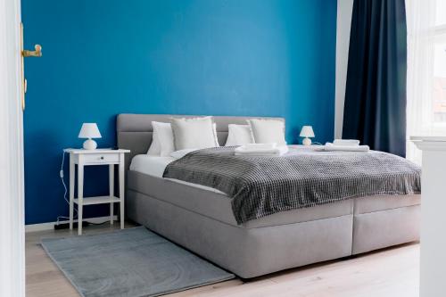 a bedroom with a bed with a blue wall at Business & Family Apartment Letna in Košice