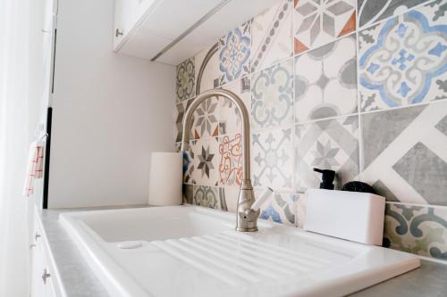 a white sink in a kitchen with tiles at Business & Family Apartment Letna in Košice