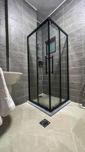 a glass shower in a bathroom with a sink at Nozoll Boutique Residences in Amman