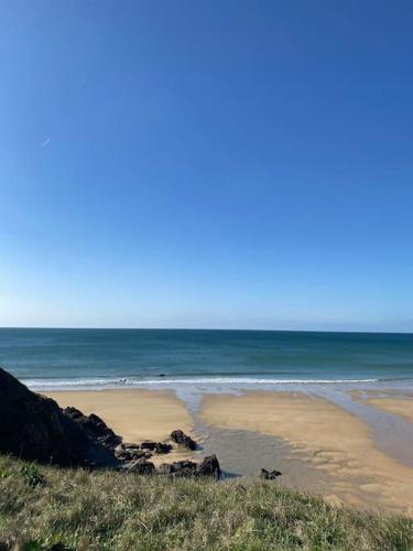 a sandy beach with the ocean in the background at Le Calypso, studio avec terrasse à 50m de la mer ! in Ploemeur