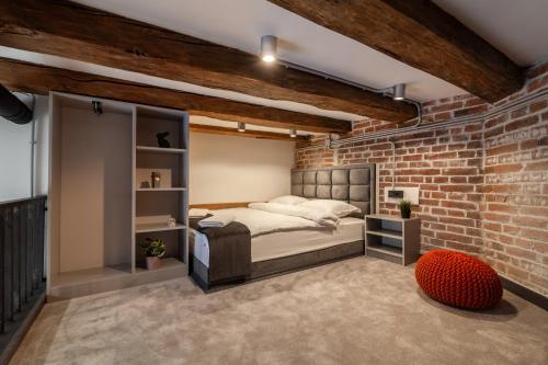 a bedroom with a bed and a brick wall at Royal mini apart-hotel on Kovzhyna in Lviv