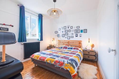 a bedroom with a bed with a colorful comforter at La Bargnia : Maison Touquettoise in Le Touquet-Paris-Plage