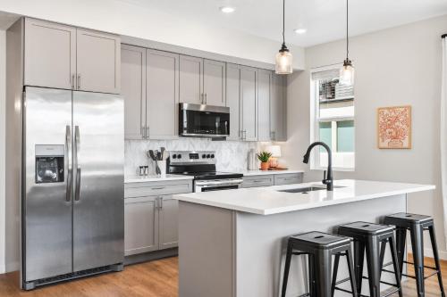 een keuken met witte kasten en een roestvrijstalen koelkast bij Paradise Cove condo in Atkinville