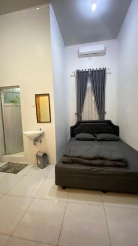 a bedroom with a bed and a sink at Livina's House in Mendut