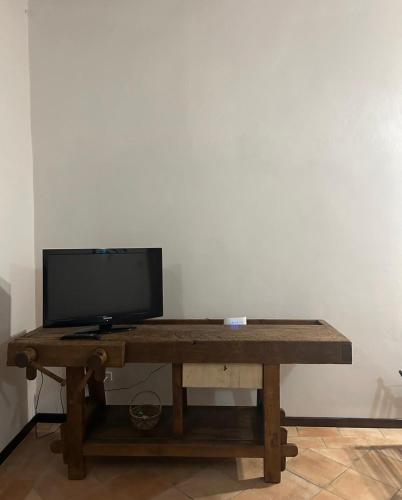 a wooden table with a television on top of it at Elisia in Terricciola