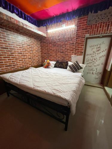 a large bed in a room with a brick wall at Mirvana Guest House & Camel safari in Jaisalmer