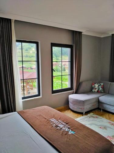 ein Schlafzimmer mit Bett, Sofa und Fenstern in der Unterkunft Anemo Suite in Uzungöl