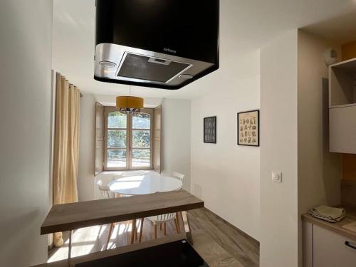 une cuisine avec évier et une télévision au plafond dans l'établissement Maison de charme à Josselin, à Josselin