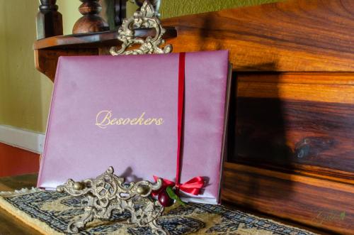 a pink book on a table with a chain at Green Gables Guest House in Upington