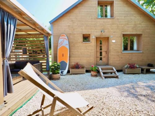 a patio with a house with a surfboard on it at Pomale Vendégház in Révfülöp