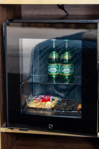 a microwave with three bottles and a pizza in it at Sleep&Fly Okęcie Warsaw Airport in Warsaw