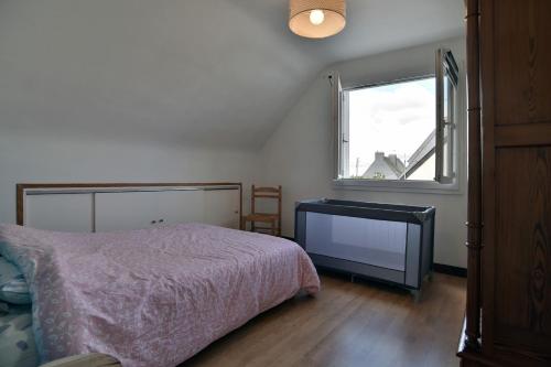 a bedroom with a bed and a window at Au Ty Mitine - A 4min en voiture de la plage in Saint-Cast-le-Guildo
