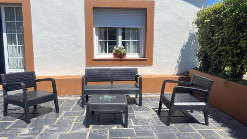 a group of chairs and a table in front of a window at Complejo la Regalina in Cadavedo