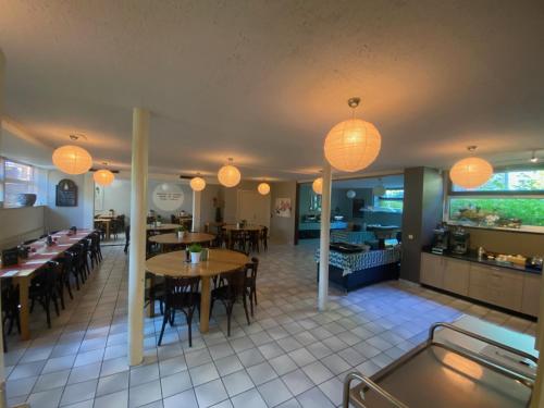 a restaurant with tables and chairs and lights at Het Huis van Bewustzijn in Limmen