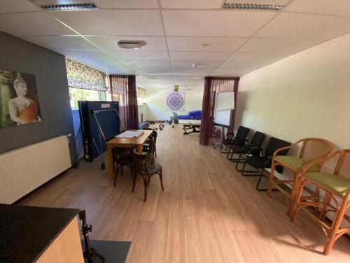 a waiting room with chairs and a table in a room at Het Huis van Bewustzijn in Limmen