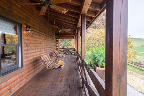 a porch of a wooden house with a ceiling fan at The Lodge at Fields of Home in Millersburg
