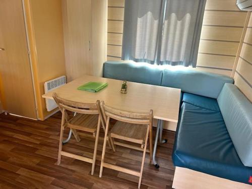 une chambre avec une table et un canapé bleu dans l'établissement 45mn de Paris Sympathique logement trois chambres - A76, à Saint-Chéron