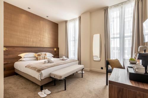 une chambre avec un grand lit et une grande fenêtre dans l'établissement Le Monsieur By Sweett, à Paris
