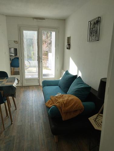 un salon avec un canapé bleu et une table dans l'établissement ocean, à Saint-Brévin-les-Pins