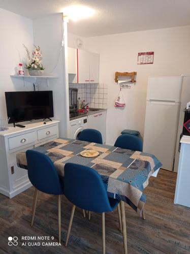 une cuisine avec une table, des chaises et un réfrigérateur dans l'établissement ocean, à Saint-Brévin-les-Pins