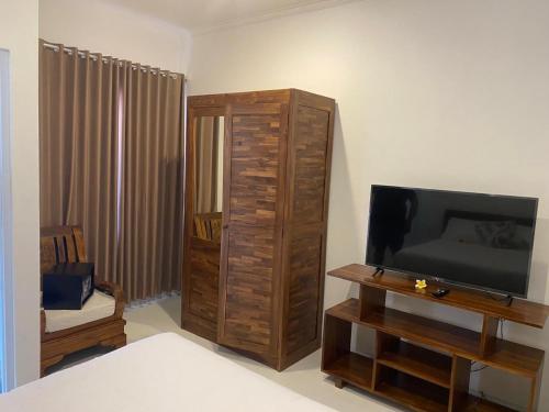 a living room with a flat screen tv and a entertainment center at Manis Guest House in Seminyak