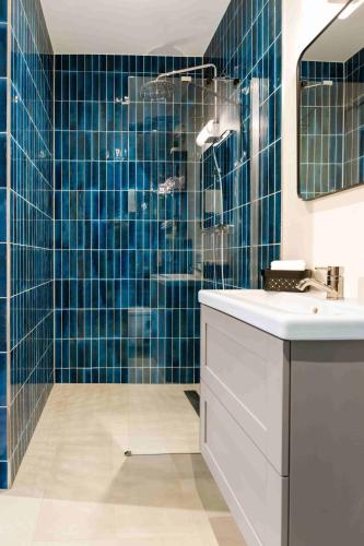 a bathroom with blue tiled walls and a shower at Hof Molenerve - -Gastenkamers- en -Vakantiewoning met strandcabine- in Domburg