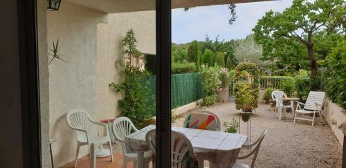 Elle offre une vue sur une terrasse avec une table et des chaises. dans l'établissement T2 Saint cyr sur mer proche de la plage, à Saint-Cyr-sur-Mer