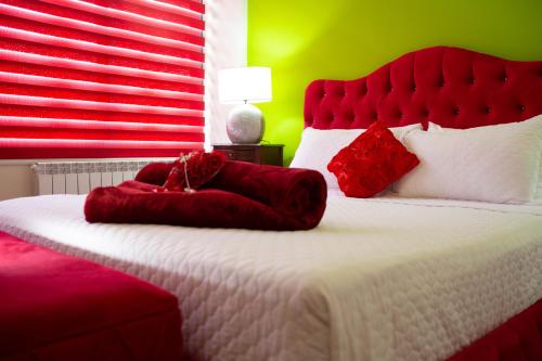 a bedroom with a large bed with red pillows at Hotel and Restaurant Shallalat Anjar in ‘Anjar