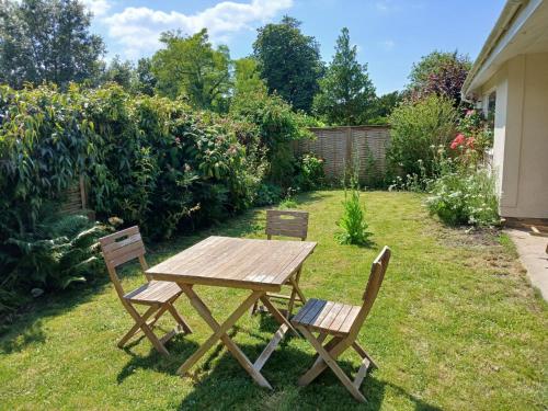 a wooden table and two chairs in a yard at Peaceful Glastonbury Bungalow - Ideally Located in Glastonbury