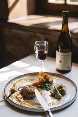 a plate of food and a glass of wine on a table at Domaine La Gentilhommière in Satillieu