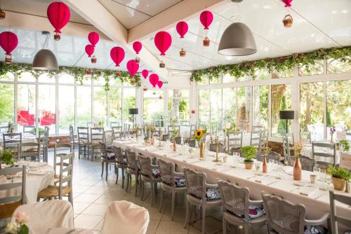 a banquet hall with tables and chairs and pink paper hearts at Domaine La Gentilhommière in Satillieu