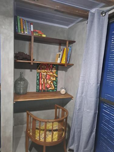 a room with a chair and a shelf with books at Mykonos Carmelo in Carmelo