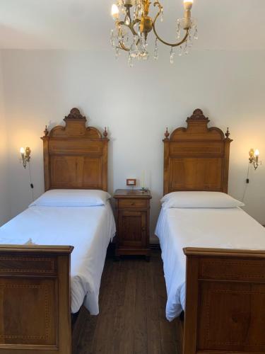 two beds with wooden headboards in a bedroom at Bed & Breakfast Casa Marinella in Lenna