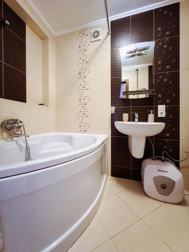 a bathroom with a white tub and a sink at Sweet Home on Shevchenko street in Vinnytsya