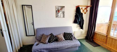 un salon avec un canapé violet et un miroir dans l'établissement Studio Vieil Alpe avec vue et garage privé, à Huez