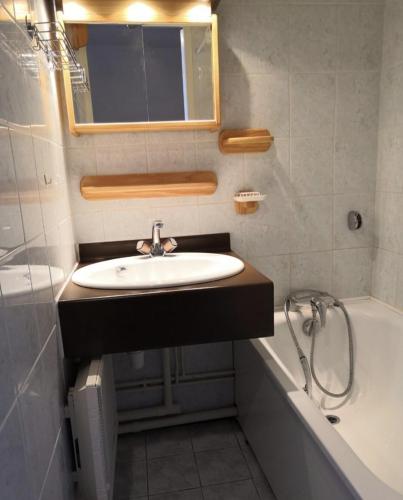 une salle de bain avec un lavabo et une baignoire dans l'établissement Studio Vieil Alpe avec vue et garage privé, à Huez