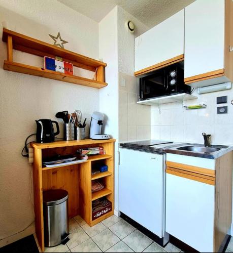 une cuisine avec un évier et un réfrigérateur blanc dans l'établissement Studio Vieil Alpe avec vue et garage privé, à Huez
