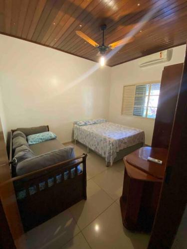 a room with a couch and a bed and a table at Casa dos chorões in Chapada dos Guimarães