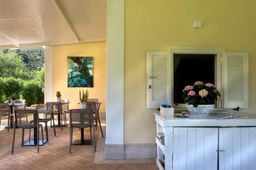 a patio with a table and chairs and a vase of flowers at Primavilla Relais in Gaeta