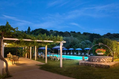 a pool with tables and chairs and umbrellas at Primavilla Relais in Gaeta