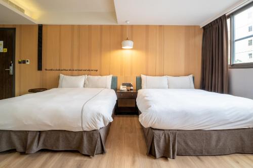 a hotel room with two beds and a desk at CHECK inn Taichung Wenxin Zhongqing in Taichung