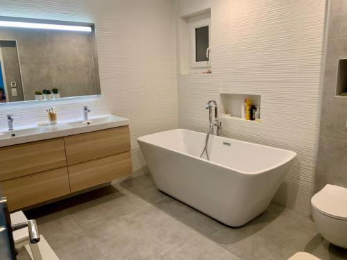 une salle de bain avec une baignoire, un lavabo et des toilettes dans l'établissement Charmante villa familiale avec piscine, à Fréjus